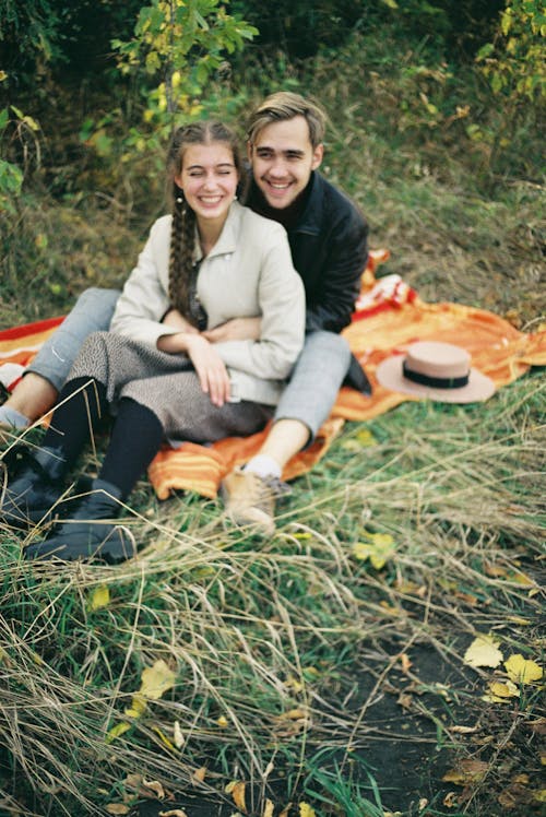 A Happy Couple Sitting on a Picnic Blanket
