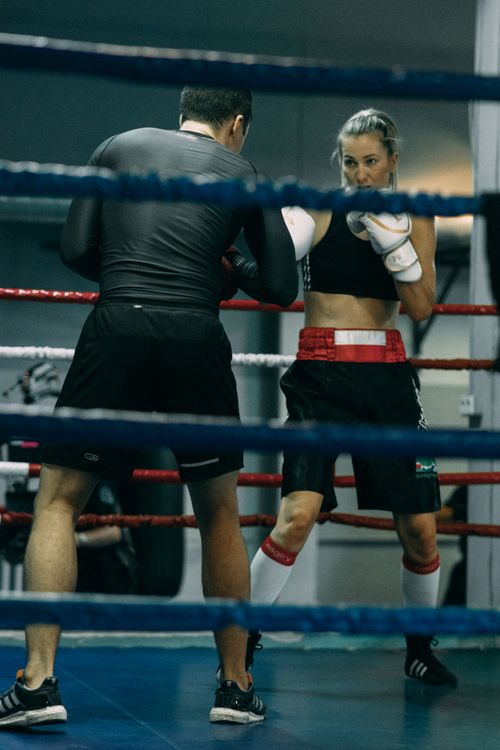 Free Man and woman sparring in a boxing ring, highlighting training, technique, and fitness. Stock Photo