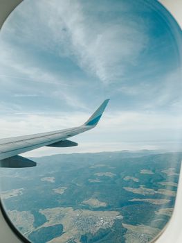 View from airplane window over Portugal's landscape with beautiful skies and clouds.