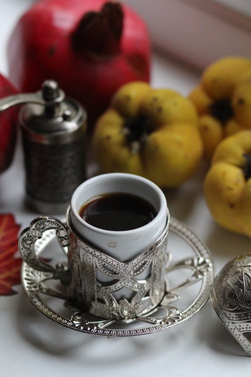 Coffee Cup Next to Pepper Mill and Fruit