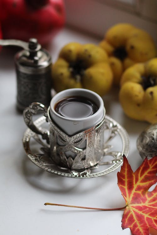 Coffee Cup Next to Pepper Mill and Fruit