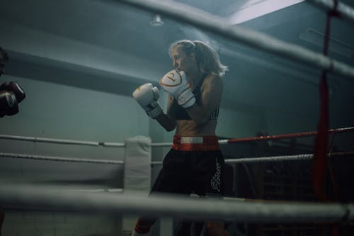 Free Woman in Wearing a White and Gold Boxing Gloves While Training Stock Photo