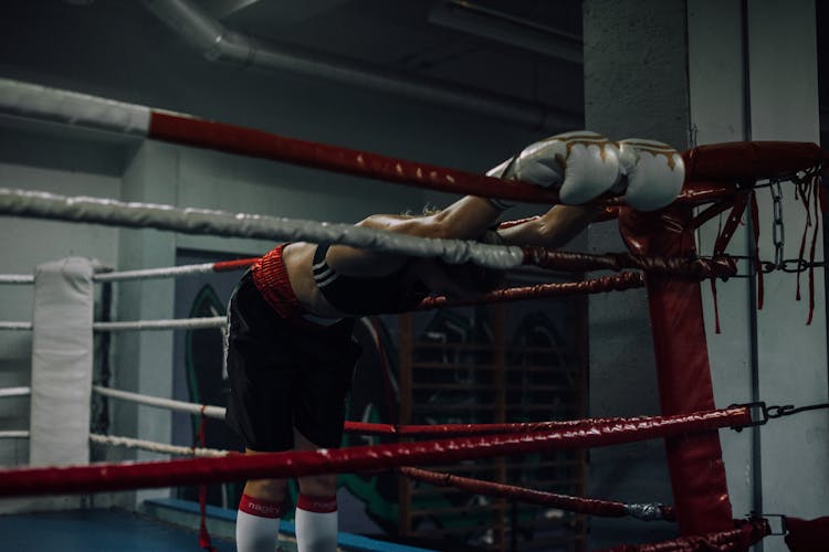 A Woman Stretching Inside The Boxing Ring