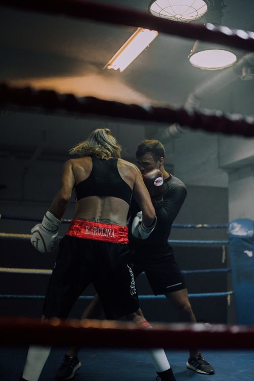 Free Two athletes sparring in a gym boxing ring, showcasing strength and focus. Stock Photo