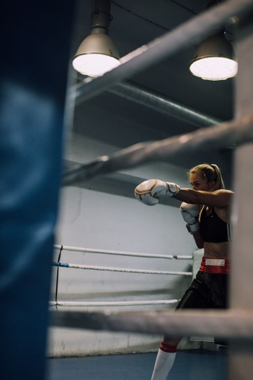 Free Focused woman shadow boxing in an indoor ring, perfecting her technique and form. Stock Photo