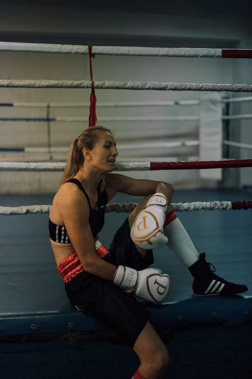 A Woman in Black Sports Bra Sitting Outside the Boxing Ring