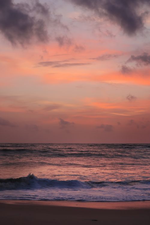 Free A stunning beach sunset with vivid hues over the Arabian Sea in Kerala, India. Stock Photo