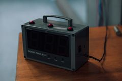 Focused view of an electronic boxing timer on a wooden surface, ideal for sports themes.
