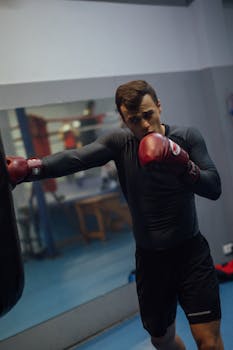 Man practicing boxing techniques in a gym with focus and determination.