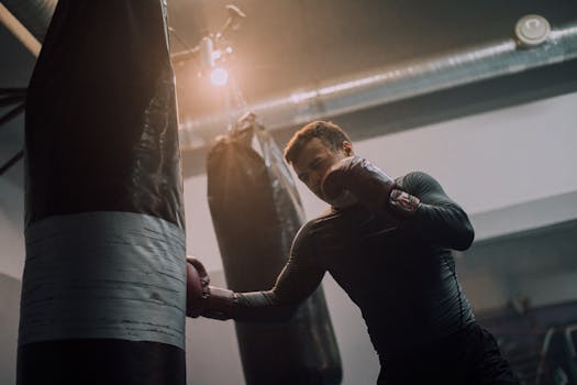 A focused athlete trains with punching bags in a modern boxing gym.