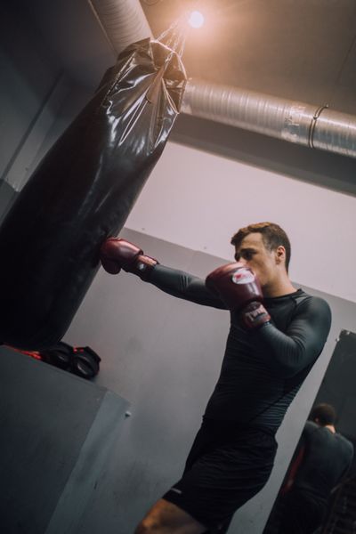 Boxer striking a heavy bag, photo by KoolShooters on Pexels