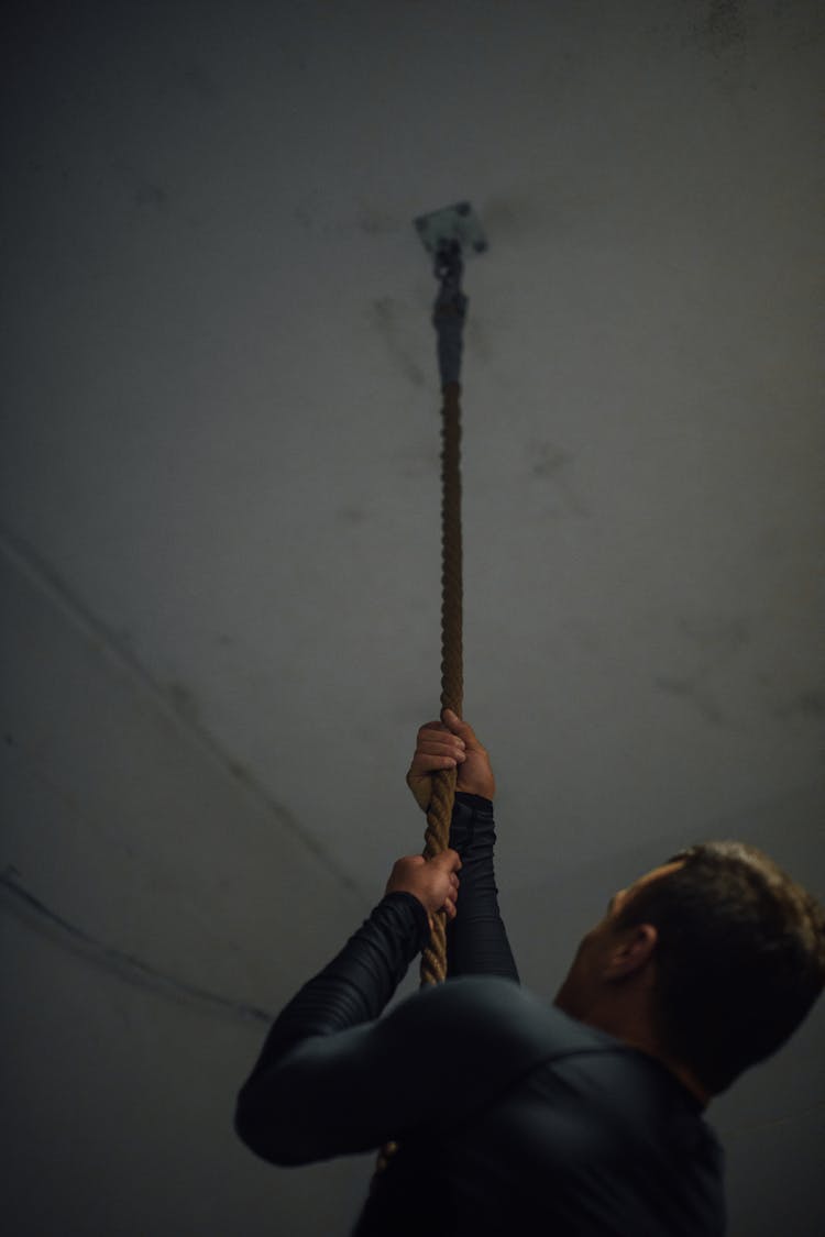 A Man Looking Up While Holding At The Rope