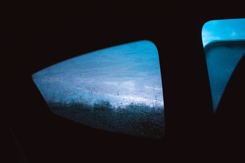 Free An artistic view through a car window with raindrops, showcasing the mood of a rainy day. Stock Photo