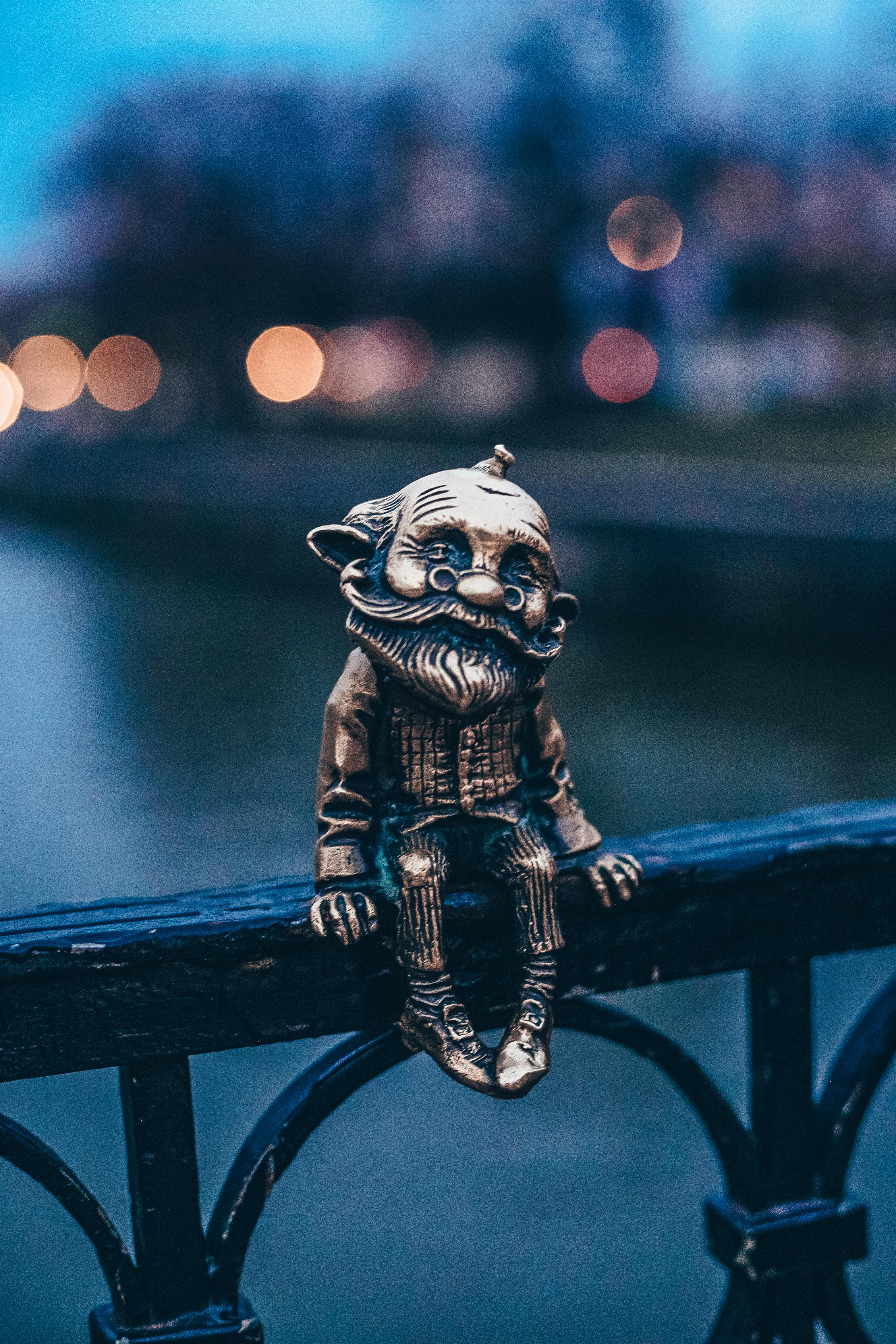 gold figurine on black metal railing