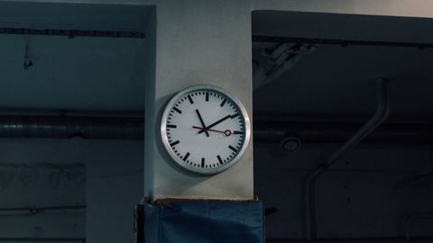 Analog wall clock in an industrial room capturing a timeless still life scene.