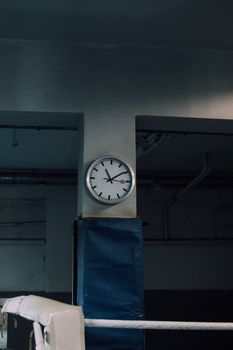 Analog wall clock in an industrial room capturing a timeless still life scene.