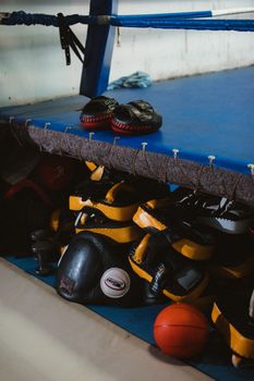 A variety of boxing equipment neatly stacked in a gym's corner.