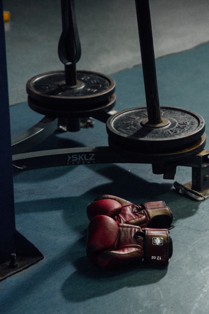 Boxing gloves resting near weight plates