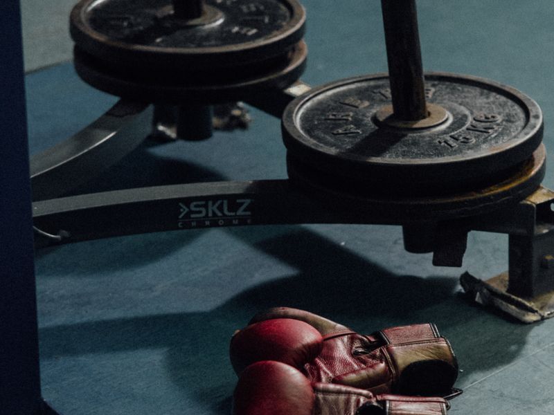 Boxing gloves beside weight plates
