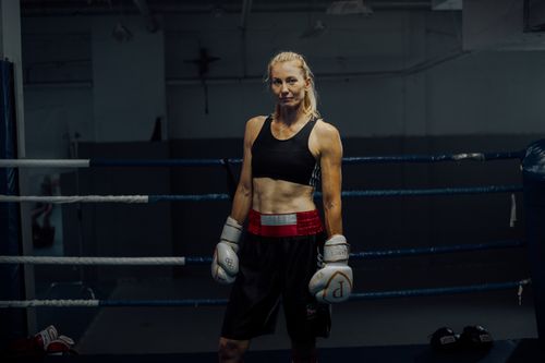 Free Strong female boxer standing confidently in the boxing ring, showcasing strength and determination. Stock Photo