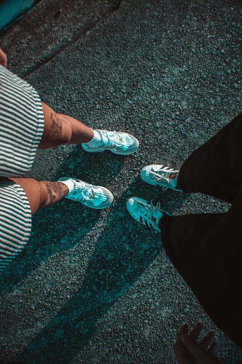 Free Person in White and Black Stripe Shirt and Black Pants Wearing White and Teal Sneakers Stock Photo