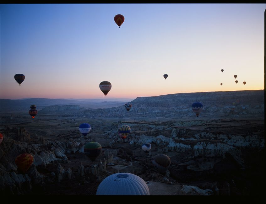 A stunning view of hot air balloons soaring over Cappadocia's landscapes at dawn.