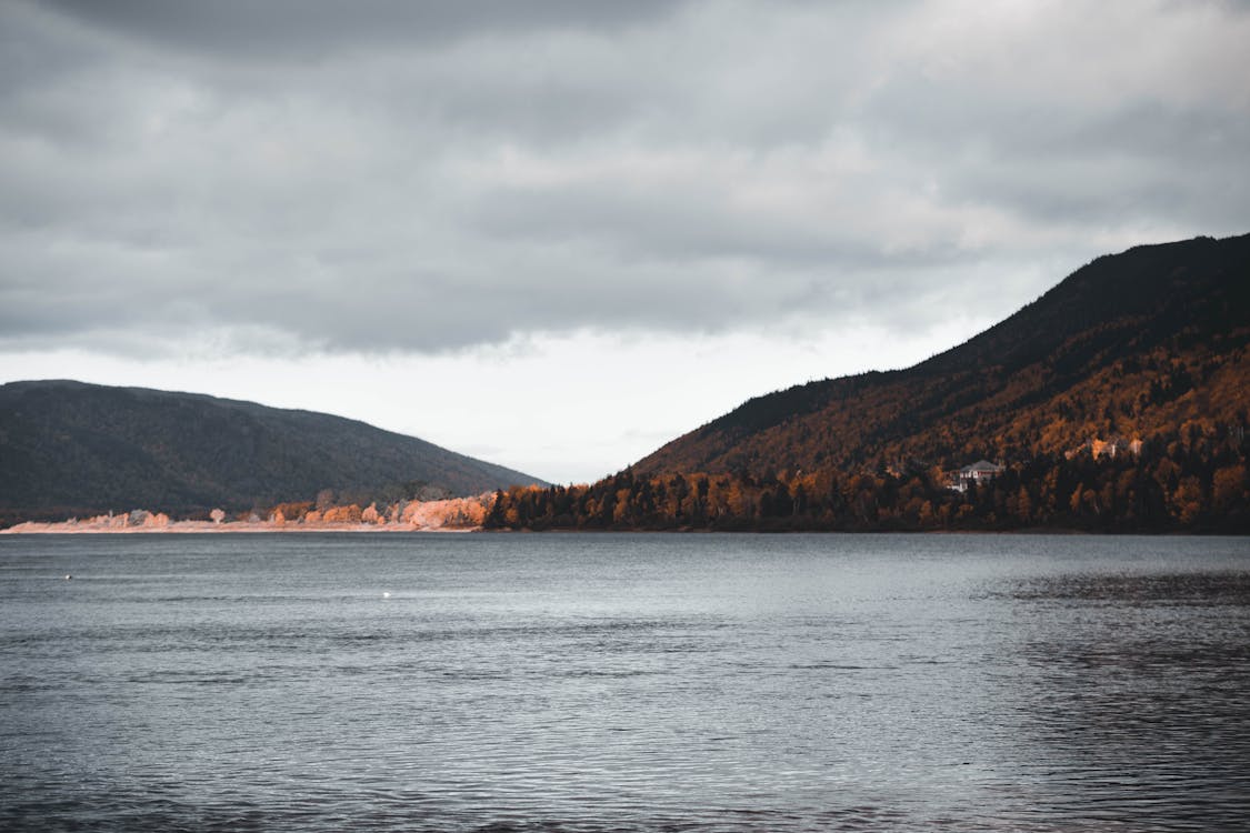 Free Overcast over Lake Surrounded by Hills Stock Photo