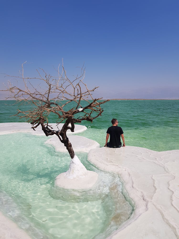 A Man Sitting On Dead Sea Salt Island