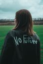 Woman in Black Coat with Statement Painted on Back