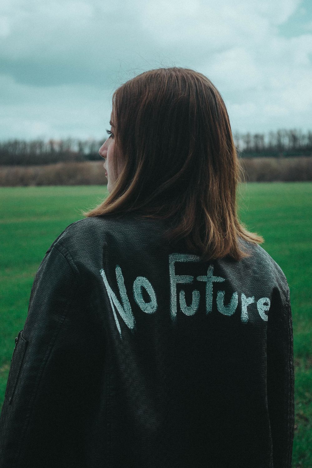 Woman in Black Coat with Statement Painted on Back · Free Stock Photo