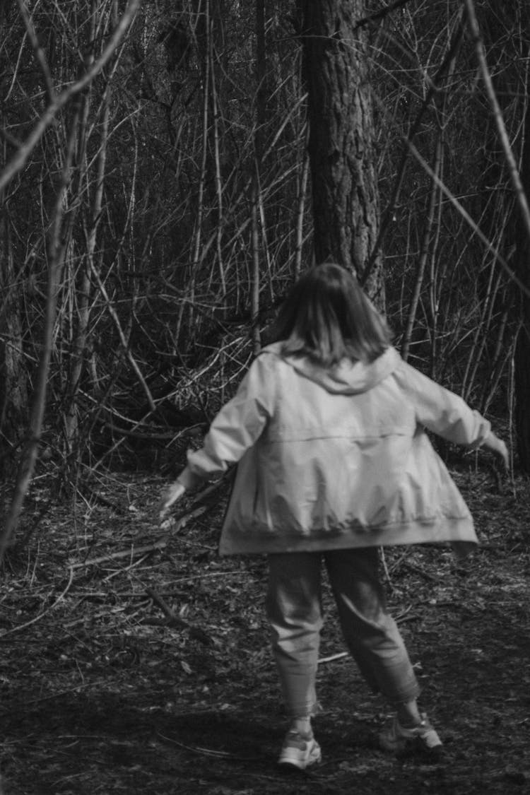 Woman In Raincoat Turning Around To Face Forest