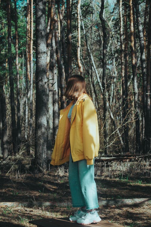 Portrait of Brown Hair Girl in Yellow Jacket Standing in Forest