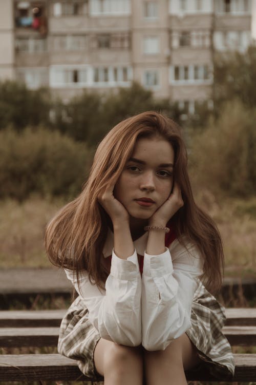 Portrait of Brown Hair Girl in White Shirt Sitting on Wooden Bench