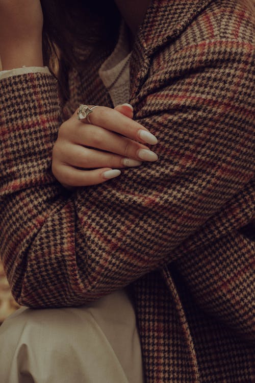 Close-up Photo of Woman's Manicured Nails on a Checkered Blazer