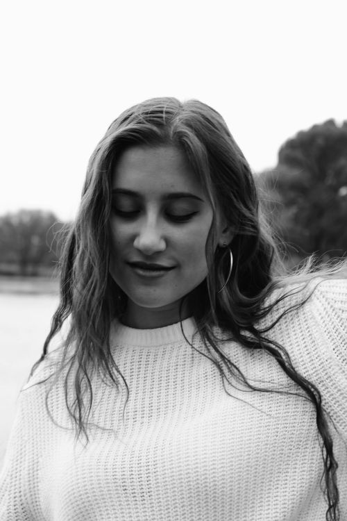 Free Serene black and white portrait of a teenage girl with long hair and closed eyes, outdoors. Stock Photo