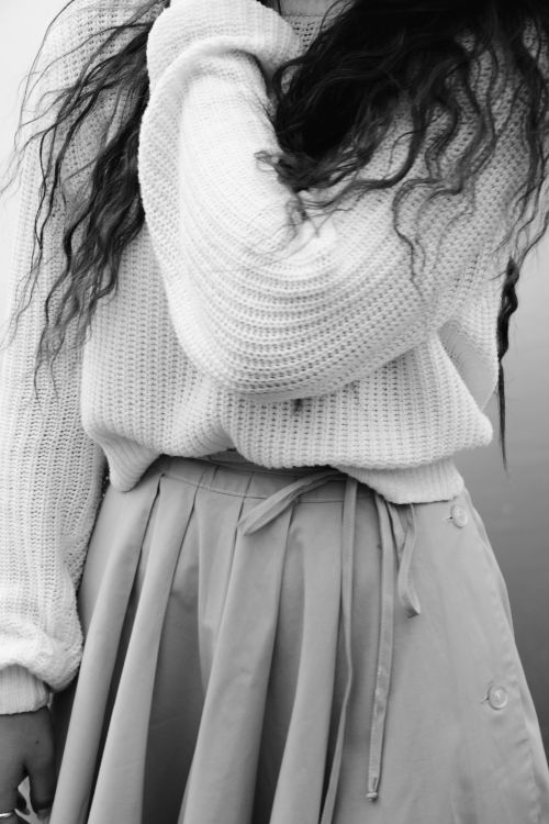Free Close-up black and white image of a woman wearing a sweater and skirt. Stock Photo
