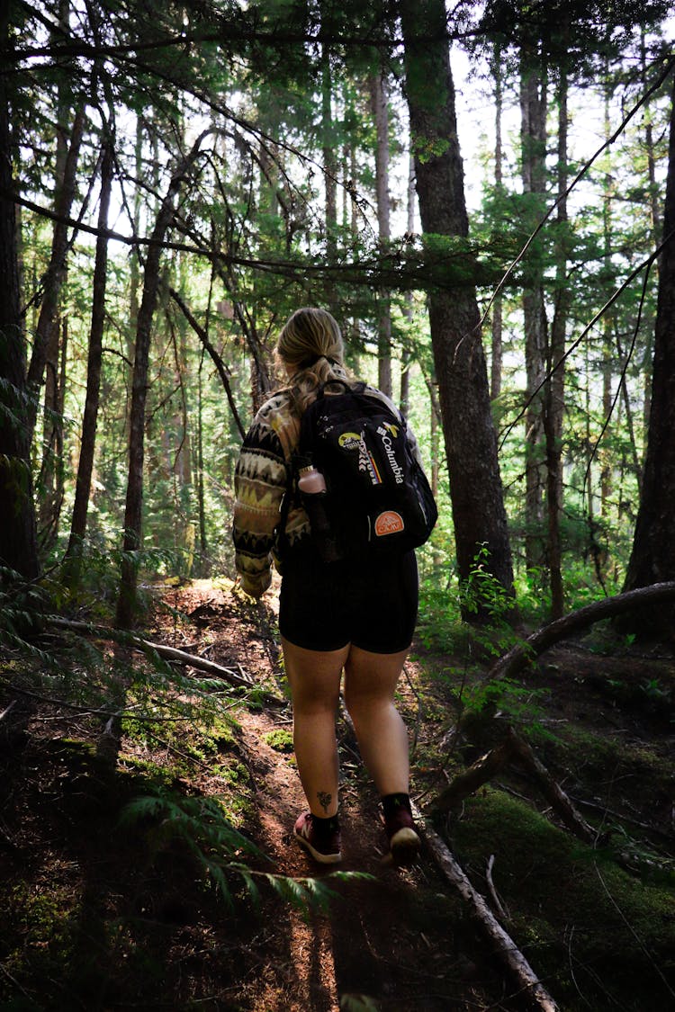 A Back View Of A Female Wearing A Back Bag And Traveling 