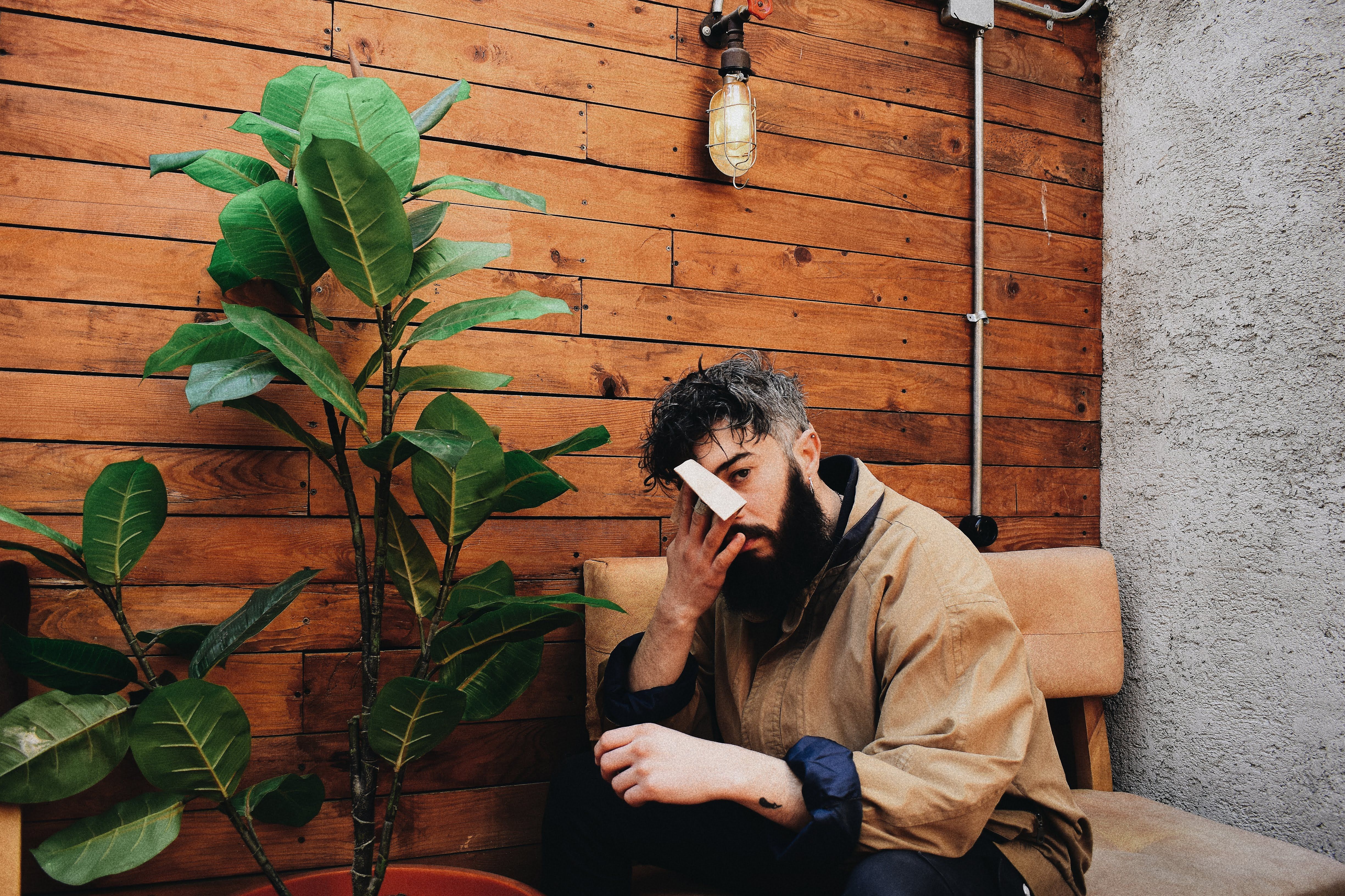 A Man in Brown Jacket Sitting on a Chair · Free Stock Photo