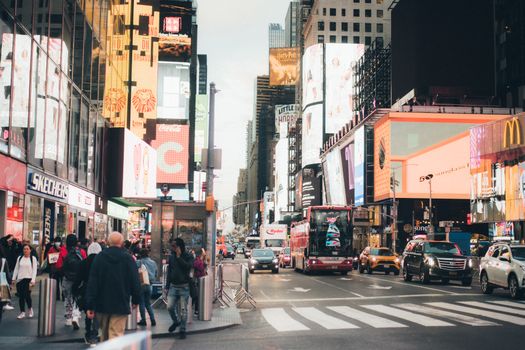 Busy Times Square in NYC, bustling with people, billboards, and traffic.