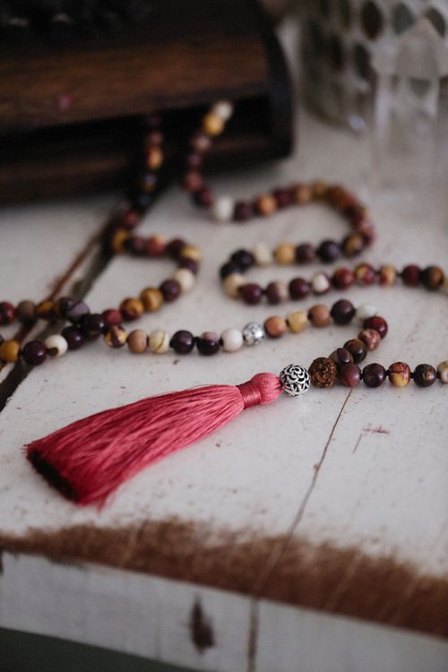 Free Close-up of a rosary with vibrant beads and tassel on a rustic table, perfect for spiritual themes. Stock Photo