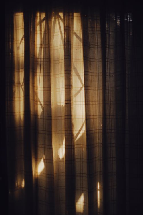 Free Sunlight filtering through checkered curtains in a serene living room setting. Stock Photo