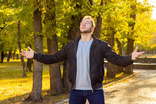 Photo of a Man in a Black Jacket Closing His Eyes