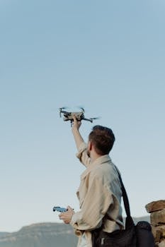 A man launches a drone in a scenic outdoor location, perfect for adventure or tech themes.