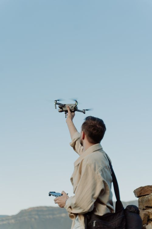 Free A man launches a drone in a scenic outdoor location, perfect for adventure or tech themes. Stock Photo