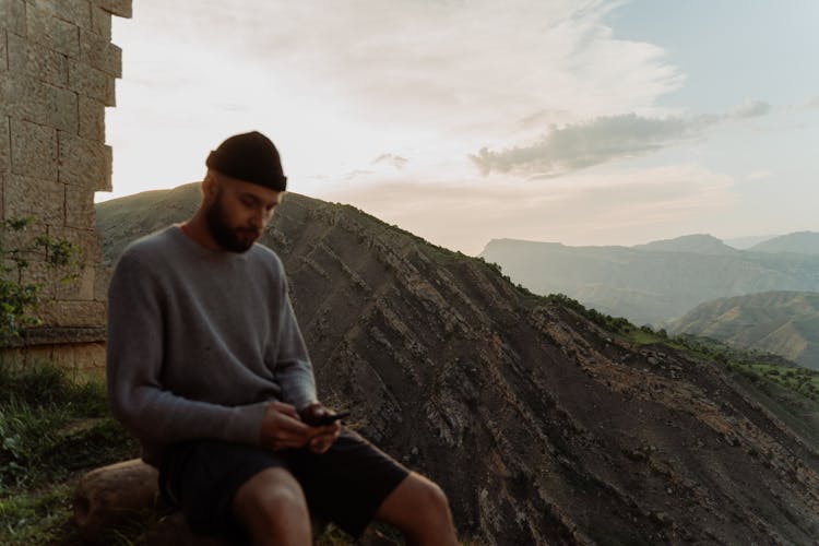 Tourist Texting Sitting By The Derbent Wall