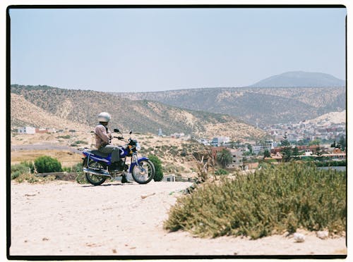 Person on Motorcycle on Hill over Town