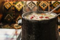 Black Ceramic Pot With Red and White Liquid