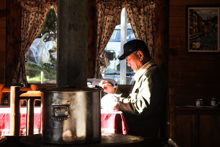 Cat On The Table Next To A Man With Black Cap 