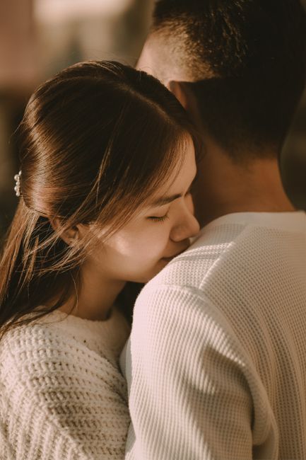 A couple embracing indoors, capturing a warm and loving moment.