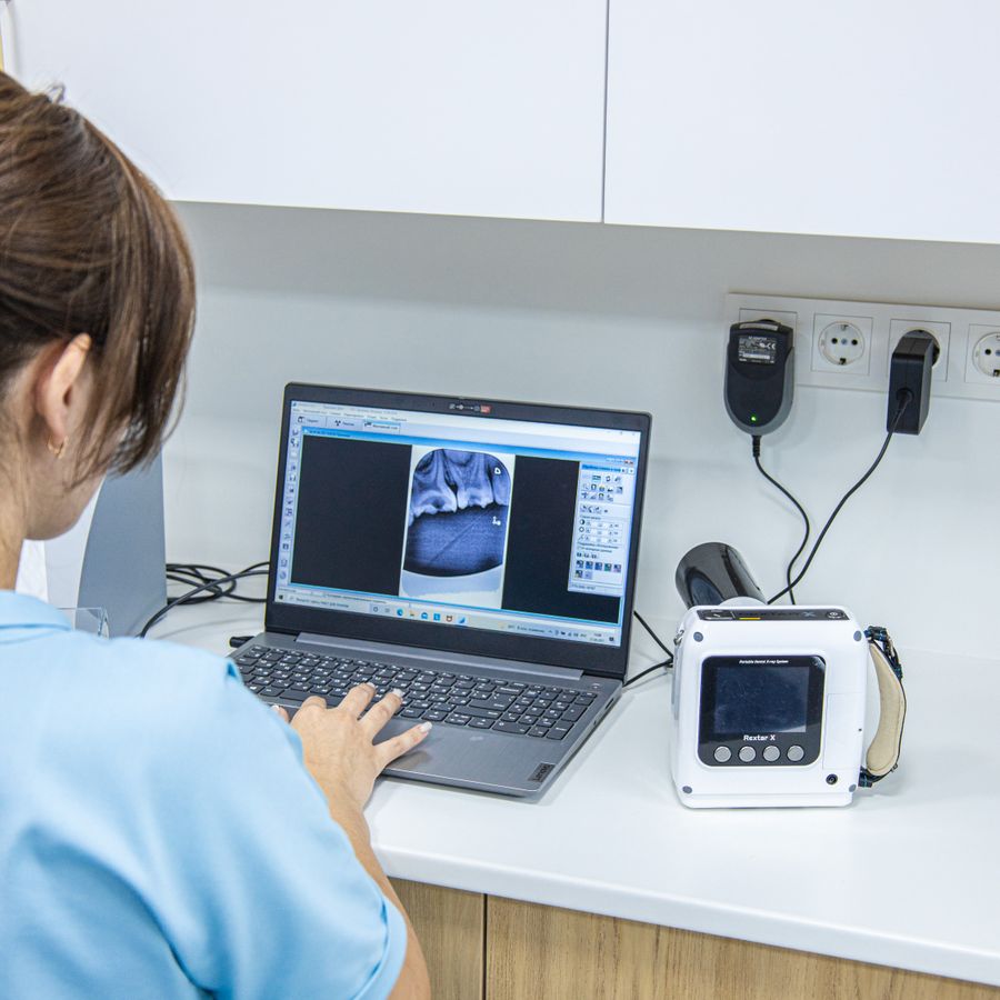 Dental professional working with digital dental imaging on a laptop